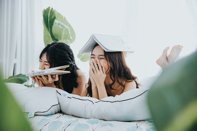 Two girls giggling with books