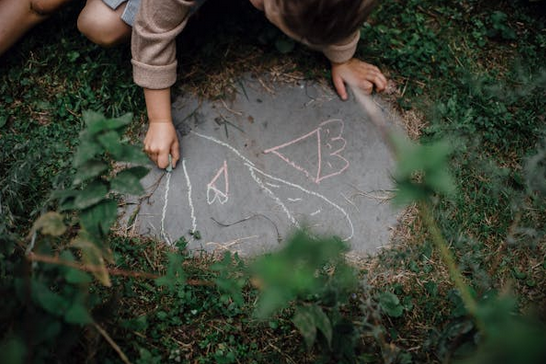 child drawing on the sidewalk with chalk