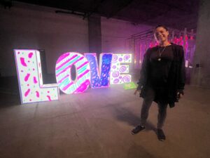 a lady standing beside LOVE sign