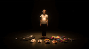 A person standing alone on a vast dark stage